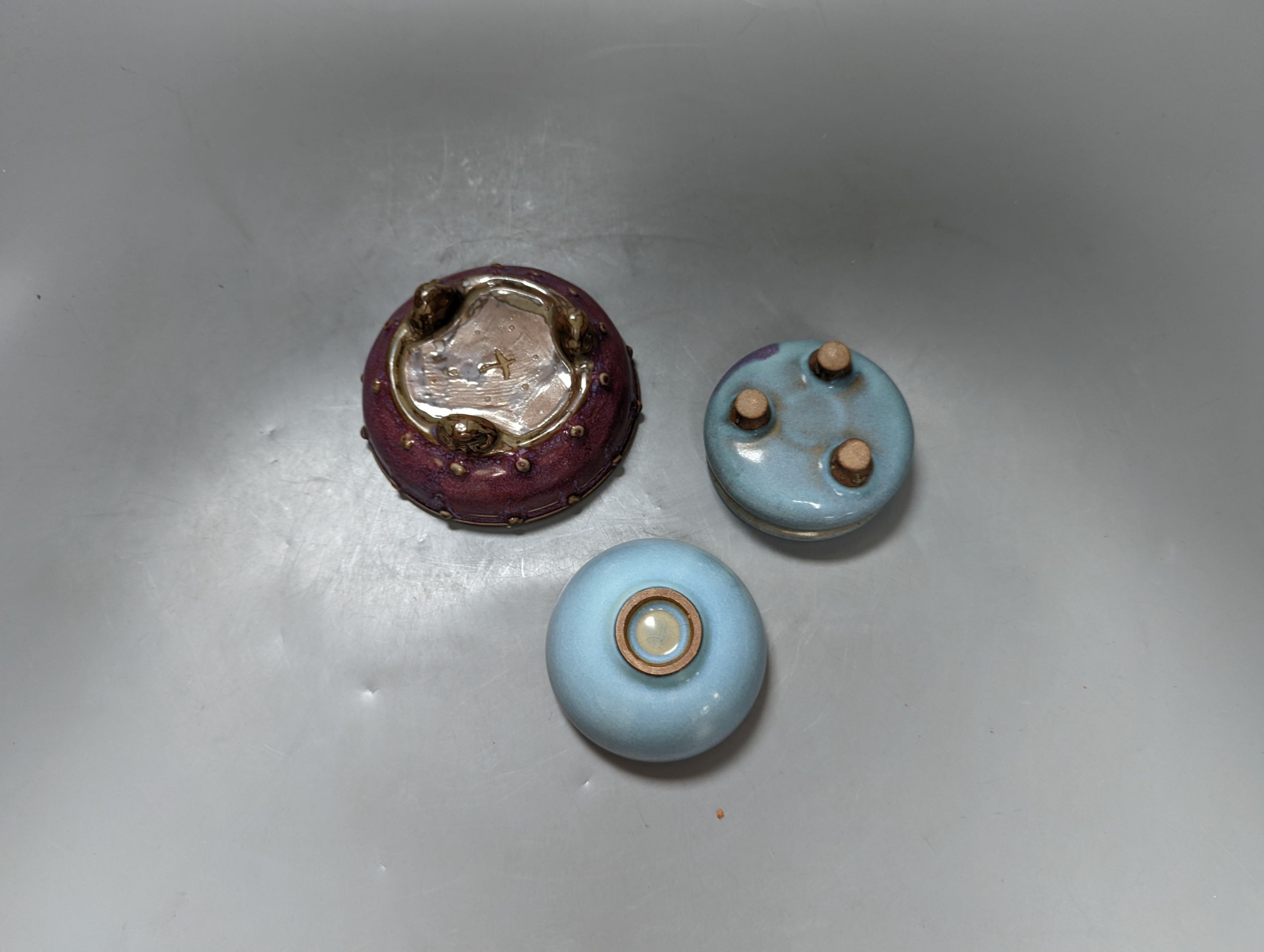 Two Chinese Jun type tripod censers and a similar cup, largest 12 cm diameter (3)